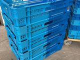 several blue plastic crates stacked on top of each other in a warehouse