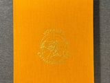 a yellow book with a logo on it sitting on top of a table