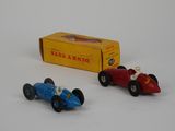 two toy cars sitting next to each other on a white surface