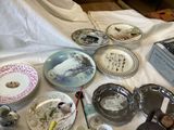 many plates and bowls on a table with a laptop in the background