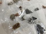 a bag of jewelry sitting on a table next to a pair of scissors