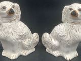 pair of white ceramic dog salt and pepper shakers on a black background