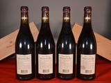 three bottles of red wine sit on a red cloth next to a wooden box