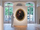 a man standing in front of a painting in an empty room