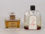 two bottles of perfume sitting next to each other on a white surface