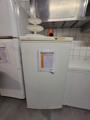 un réfrigérateur blanc dans une petite cuisine équipée d'une cuisinière