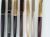 many different types of pens lined up on a white surface