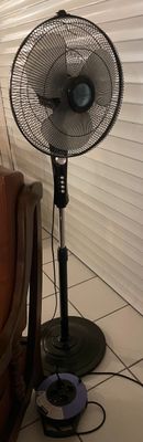 un ventilateur posé par terre à côté d'une chaise