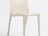 une chaise en plastique blanche posée sur une surface blanche, avec un fond blanc