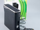 une Xbox 360 et une manette de jeu posées à côté d'un carton