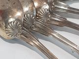 five silverware spoons on a white table