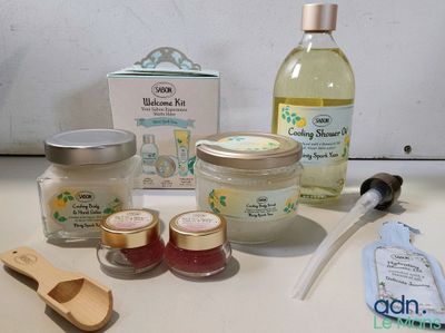 a bottle of liquid, a bottle of toothpaste, a jar of toothpaste, a wooden spoon, and a bottle of toothpaste
