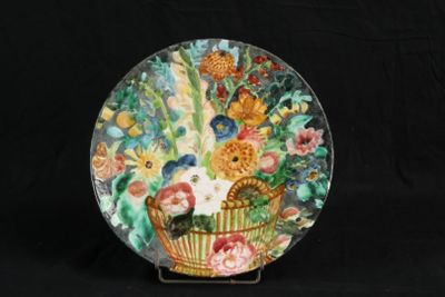 une assiette décorative sur laquelle est représenté un panier de fleurs