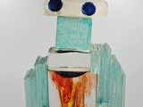a sculpture of a robot made of glass on a pedestal