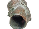 a small bronze object that is on a white surface