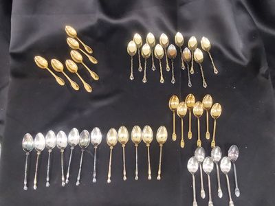 many spoons and spoon spoons laid out on a black cloth