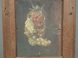 painting of a bunch of grapes in a wooden frame on an easel