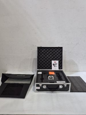 une mallette noire contenant un objet orange, posée sur une table blanche
