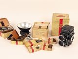 many different types of cameras and boxes on the table