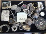 une boîte noire remplie d'objets en argent de toutes sortes, posée sur une table