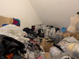 a pile of clothes and a mannequin in the corner of a room