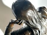 a statue of a woman holding a cell phone to her ear
