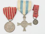deux médailles et une médaille sont posées sur une surface blanche