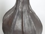 a brown vase that is sitting on a white surface