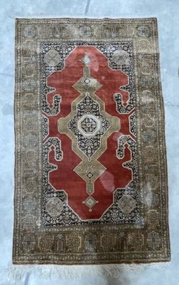 un gros plan sur un tapis posé sur un lit recouvert d'un drap blanc