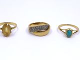 three gold rings and a turquoise stone ring