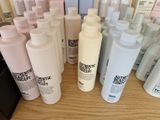 many bottles of different types of hair products on a table