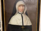 painting of a nun holding a book in a black frame