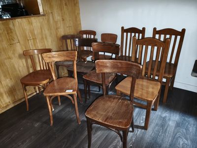 de nombreuses chaises en bois et une table dans une pièce
