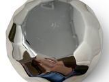 a silver bowl with a reflection of a person in it