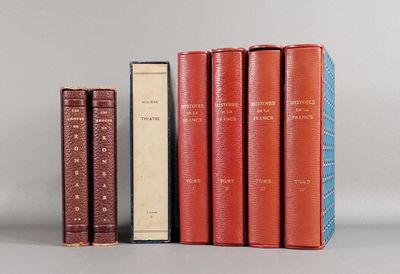 trois livres sont alignés les uns à côté des autres sur une surface grise