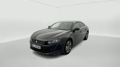 Une voiture grise est garée dans une pièce blanche au sol blanc.