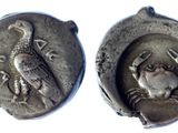 two ancient silver coins with a bird and a bird on them