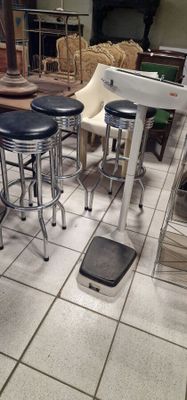 several stools and a table in a room with a lot of furniture