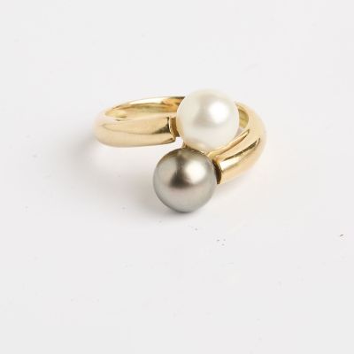 Gros plan sur une bague en or ornée de deux perles