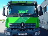 un camion vert garé devant un immeuble