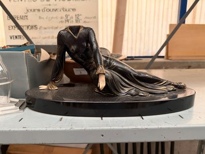 a statue of a woman laying down on a table