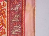 a close up of a pink and orange scarf with a design on it