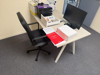 a desk with a computer, printer, and other items on it