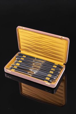 six knives in a wooden case on a black surface