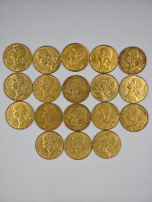 a close up of a pile of gold coins on a white surface
