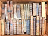 une boîte pleine de vieux livres posée sur le sol