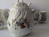 a tea pot and cups on a table with plates