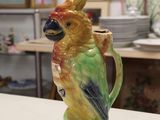 a ceramic bird that is sitting on top of a coffee cup