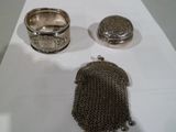un porte-monnaie en argent et une bague en argent posés sur une table