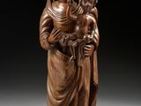 une statue en bois représentant une femme tenant un enfant dans ses bras